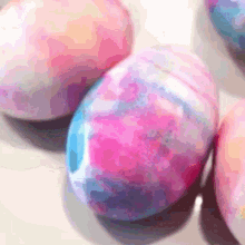 a bunch of pink and blue easter eggs sitting on a table