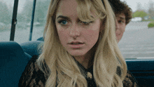 a woman with blonde hair is sitting in a car