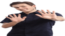 a young man in a black shirt is making a stop sign with his hands