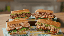 four subway sandwiches are sitting on a table