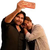 a man taking a selfie with another man while wearing a shirt that says den