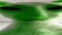 a close up of a green alien 's face with big eyes .