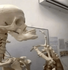 a skeleton is holding a saxophone in a room with a fan .