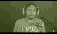 a man wearing headphones and a shirt that says haters on it