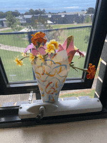 a vase filled with flowers sits on a window sill next to a viridian brand window