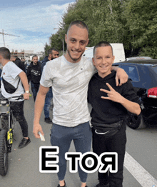 a man and a boy are posing for a picture with the word e toa on the bottom right