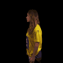 a woman wearing a yellow shirt that says uhlsport