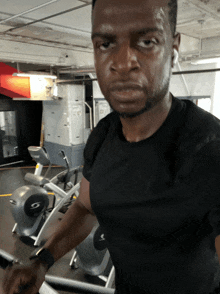 a man in a black shirt is sweating while riding an exercise bike