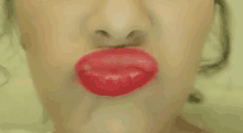 a close up of a woman 's face with red lipstick on .