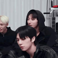 a group of young men are sitting next to each other in a room .