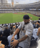 a man in a padres jersey stands in a stadium