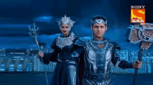 a man and a woman are standing next to each other in armor holding swords .