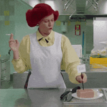 a woman with red hair is smoking a cigarette while cutting a piece of ham