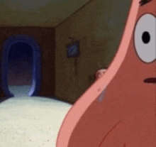 patrick star from spongebob squarepants is standing in front of a doorway .