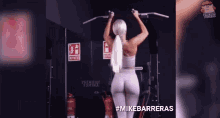 a woman is doing a pull up exercise in a gym .