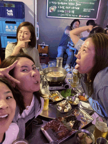 a group of women are posing for a picture in front of a sign that says jinro so