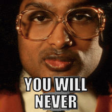 a close up of a man wearing glasses with the words you will never below him