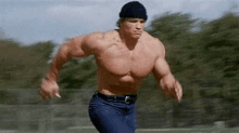 arnold schwarzenegger is running without a shirt on while wearing a beanie .