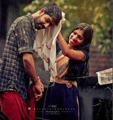 a man and a woman are holding hands in the rain