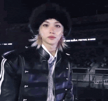 a close up of a person wearing a black hat and a black jacket .