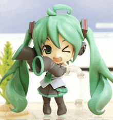 a figurine of hatsune miku is holding a microphone and making a funny face