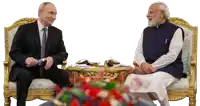 a man in a suit and tie sits next to a man in a white shirt