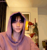a young man wearing a purple hoodie and a necklace with the name pabeyork on the bottom