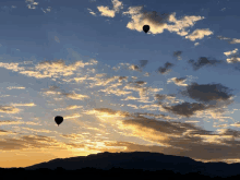 three hot air balloons flying in the sky at sunset