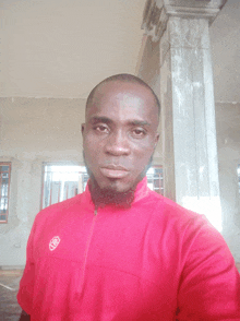 a man wearing a red shirt with the letters nb on the front