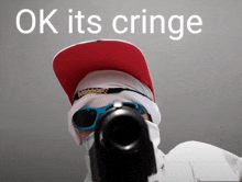 a man wearing sunglasses and a hat holds a gun in front of a sign that says ok it 's cringe