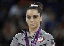 a female gymnast wearing a medal that says london 2012