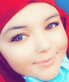 a close up of a woman 's face with a red hijab on