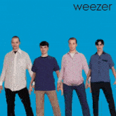 a group of men standing next to each other on a blue background with the word weezer on it