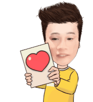 a man in a yellow shirt is holding a piece of paper with a red heart on it