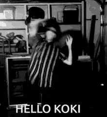 a black and white photo of a person dancing with the words hello koki written on the bottom .