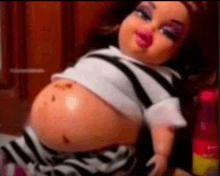 a doll with a very large belly is wearing a striped shirt