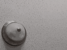 a light fixture on a gray ceiling with a few small dots on it