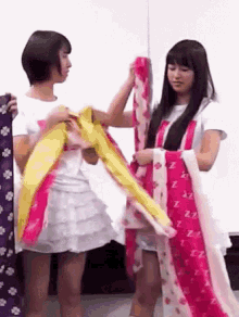 two girls are standing next to each other and one of them is wearing a pink scarf with zzz on it