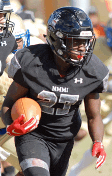 a football player wearing a black jersey with nmmi on it