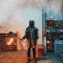 a man wearing a helmet is holding a torch in a room with boxes on shelves