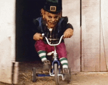 a leprechaun is riding a tricycle in front of a wooden building .