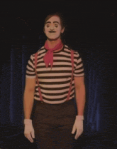 a man dressed as a mime with white face paint and suspenders