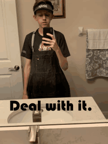 a boy in an apron takes a selfie in front of a mirror with the words deal with it below him