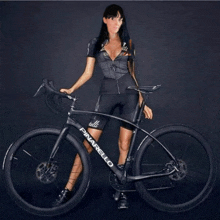 a woman is standing next to a black pinarello bike