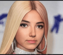 a close up of a woman 's face with blonde hair and pink hair