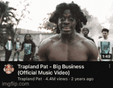 a man without a shirt is standing in front of a group of people and says trapland pat big business