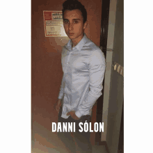 a man in a light blue shirt is standing in front of a door with the name danni solon on the bottom