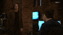 two men standing next to each other in front of a screen that says nbc on it