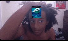 a shirtless young man with a picture of a dolphin on his forehead