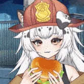 a girl wearing a fireman 's hat holds a hamburger